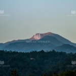 Glowing Mountain Top seen among the misty Forest land.